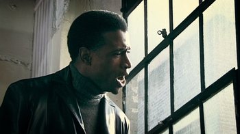 Movie still from “Bamboozled” (2000), directed by Spike Lee – A man in a leather jacket looking out of a window; Close Up shot, Low angle