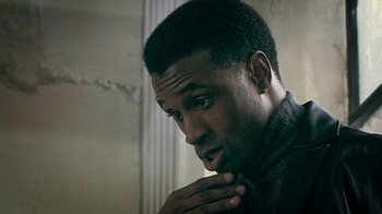 Movie still from “Bamboozled” (2000), directed by Spike Lee – A person wearing a suit and tie; Close Up shot, Over the shoulder angle