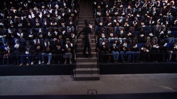 Movie still from “Bamboozled” (2000), directed by Spike Lee – A man standing on a set of stairs in front of a group of people; Extreme Wide shot, High angle