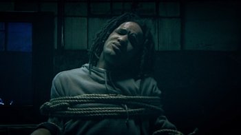 Movie still from “Bamboozled” (2000), directed by Spike Lee – A man with dreadlocks tied up in a room; Close Up shot, Low angle