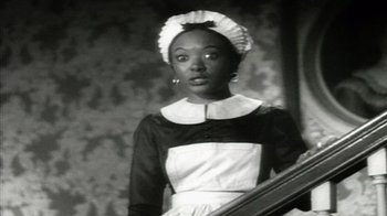 Movie still from “Bamboozled” (2000), directed by Spike Lee – A black and white photo of a woman in a maid's outfit; Medium shot, High angle