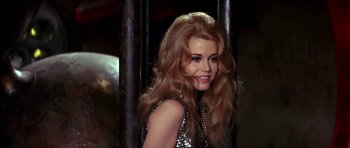 Movie still from “Barbarella” (1968), directed by Roger Vadim – A woman with long red hair smiling for the camera; Close Up shot, Low angle