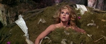 Movie still from “Barbarella” (1968), directed by Roger Vadim – A woman laying on top of a pile of hay; Medium shot, High angle