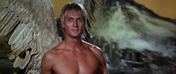 Movie still from “Barbarella” (1968), directed by Roger Vadim – A man with no shirt is standing in front of a tree; Close Up shot, Low angle