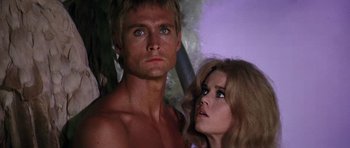 Movie still from “Barbarella” (1968), directed by Roger Vadim – A man and a woman standing next to each other in front of trees; Close Up shot, Low angle