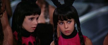 Movie still from “Barbarella” (1968), directed by Roger Vadim – Two young girls with long black hair and bunny ears; Close Up shot, Over the shoulder angle