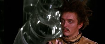 Movie still from “Barbarella” (1968), directed by Roger Vadim – A man with long brown hair and a mustache; Close Up shot, Low angle