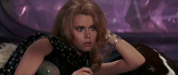 Movie still from “Barbarella” (1968), directed by Roger Vadim – A woman holding a bottle in her hand; Close Up shot, Low angle