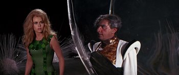 Movie still from “Barbarella” (1968), directed by Roger Vadim – A man in a white shirt and a woman in a black and white dress; Medium shot, Over the shoulder angle