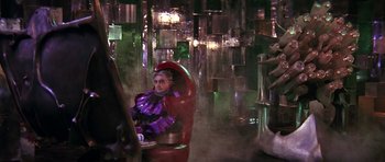 Movie still from “Barbarella” (1968), directed by Roger Vadim – A man sitting in a chair in a room with lights; Wide shot, High angle