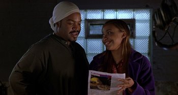Movie still from “Barbershop” (2002), directed by Tim Story – A man and a woman are looking at a newspaper; Close Up shot, Over the shoulder angle