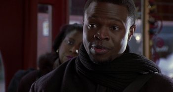 Movie still from “Barbershop” (2002), directed by Tim Story – A person wearing a scarf; Close Up shot, Over the shoulder angle