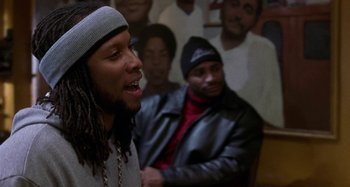 Movie still from “Barbershop” (2002), directed by Tim Story – A man with long dreadlocks is talking to a crowd; Close Up shot, Over the shoulder angle