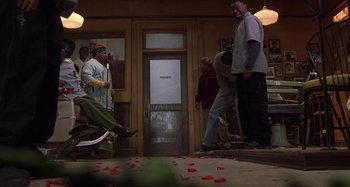 Movie still from “Barbershop” (2002), directed by Tim Story – A group of people standing in front of a door; Wide shot, High angle