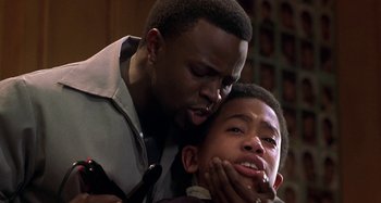 Movie still from “Barbershop” (2002), directed by Tim Story – A man and a young boy are grooming each other; Close Up shot, Over the shoulder angle