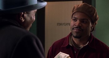 Movie still from “Barbershop” (2002), directed by Tim Story – A man in a brown hat is talking to another man in a red shirt; Close Up shot, Over the shoulder angle