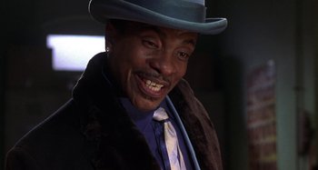 Movie still from “Barbershop” (2002), directed by Tim Story – A person wearing a hat and a tie; Close Up shot, Low angle