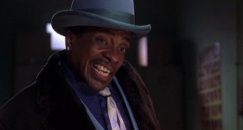 Movie still from “Barbershop” (2002), directed by Tim Story – A person wearing a hat and a tie; Close Up shot, Low angle