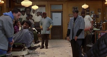 Movie still from “Barbershop” (2002), directed by Tim Story – A group of men standing in front of a barber shop; Wide shot, Over the shoulder angle