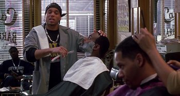 Movie still from “Barbershop” (2002), directed by Tim Story – Two men are getting their hair cut in a barber shop; Medium shot, Over the shoulder angle