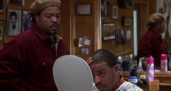 Movie still from “Barbershop” (2002), directed by Tim Story – A man getting his hair cut in a barber shop; Close Up shot, Over the shoulder angle