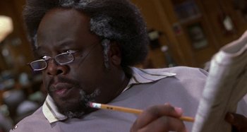 Movie still from “Barbershop” (2002), directed by Tim Story – A person holding a pencil; Close Up shot, High angle