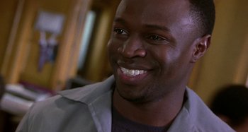 Movie still from “Barbershop” (2002), directed by Tim Story – A person with a smile on his face; Close Up shot, Low angle