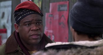 Movie still from “Barbershop” (2002), directed by Tim Story – A man wearing a red hat talking to another man; Close Up shot, Over the shoulder angle