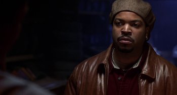 Movie still from “Barbershop” (2002), directed by Tim Story – A person wearing a jacket and a hat; Close Up shot, Over the shoulder angle