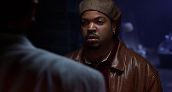 Movie still from “Barbershop” (2002), directed by Tim Story – A man wearing a hat and a leather jacket; Close Up shot, Over the shoulder angle