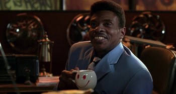 Movie still from “Barbershop” (2002), directed by Tim Story – A man sitting at a table holding a coffee mug; Close Up shot, Low angle