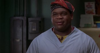 Movie still from “Barbershop” (2002), directed by Tim Story – A man wearing a red hat and a white shirt; Close Up shot, Low angle