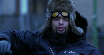 Movie still from “Barbershop” (2002), directed by Tim Story – A man wearing a fur hat and goggles; Close Up shot, Low angle
