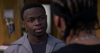 Movie still from “Barbershop” (2002), directed by Tim Story – A man is talking to another man in front of him; Close Up shot, Over the shoulder angle