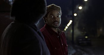 Movie still from “Barbershop” (2002), directed by Tim Story – A man wearing a brown hat and a red shirt; Close Up shot, Over the shoulder angle