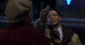 Movie still from “Barbershop” (2002), directed by Tim Story – A man holding a cell phone up to his face; Close Up shot, Over the shoulder angle