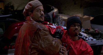 Movie still from “Barbershop” (2002), directed by Tim Story – A couple of men standing next to each other; Medium shot, Over the shoulder angle