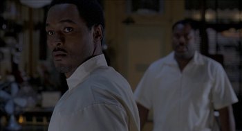 Movie still from “Barbershop 2: Back in Business” (2004), directed by Kevin Rodney Sullivan – Two men in white shirts are standing next to each other; Close Up shot, Over the shoulder angle
