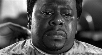 Movie still from “Barbershop 2: Back in Business” (2004), directed by Kevin Rodney Sullivan – A black and white photo of a man's face; Close Up shot, Low angle