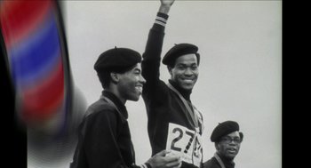 Movie still from “Barbershop 2: Back in Business” (2004), directed by Kevin Rodney Sullivan – A black and white photo of two men in hats and one is holding up his hand; Medium shot, Low angle