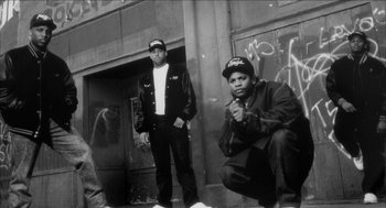 Movie still from “Barbershop 2: Back in Business” (2004), directed by Kevin Rodney Sullivan – A black and white photo of two men standing next to each other in front of a building; Wide shot, Low angle