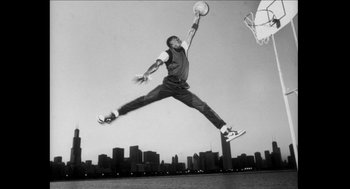 Movie still from “Barbershop 2: Back in Business” (2004), directed by Kevin Rodney Sullivan – A man jumping in the air with a basketball in his hand; Wide shot, Low angle