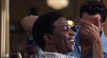 Movie still from “Barbershop 2: Back in Business” (2004), directed by Kevin Rodney Sullivan – A man smiles as he gets his hair cut; Close Up shot, Over the shoulder angle