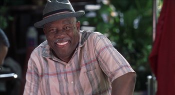 Movie still from “Barbershop 2: Back in Business” (2004), directed by Kevin Rodney Sullivan – A man in a hat smiling for the camera; Close Up shot, Low angle