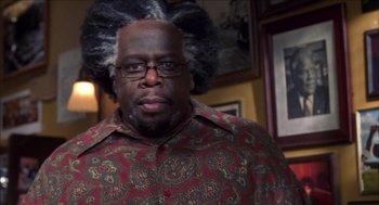 Movie still from “Barbershop 2: Back in Business” (2004), directed by Kevin Rodney Sullivan – A person wearing a shirt and glasses; Close Up shot, Low angle
