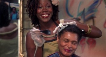 Movie still from “Barbershop 2: Back in Business” (2004), directed by Kevin Rodney Sullivan – A woman getting her hair done by a stylist; Close Up shot, Over the shoulder angle