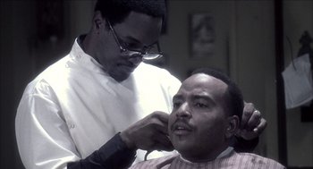 Movie still from “Barbershop 2: Back in Business” (2004), directed by Kevin Rodney Sullivan – A man getting his hair cut by another man; Close Up shot, Over the shoulder angle