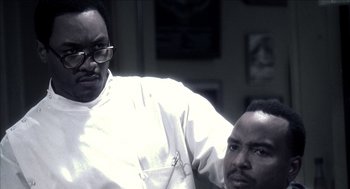 Movie still from “Barbershop 2: Back in Business” (2004), directed by Kevin Rodney Sullivan – Two men standing next to each other in front of a wall; Close Up shot, Over the shoulder angle