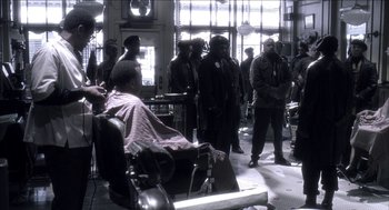Movie still from “Barbershop 2: Back in Business” (2004), directed by Kevin Rodney Sullivan – A group of men standing around a barber shop; Wide shot, Over the shoulder angle