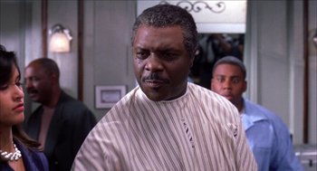 Movie still from “Barbershop 2: Back in Business” (2004), directed by Kevin Rodney Sullivan – An older man in a striped shirt is looking at the camera; Close Up shot, Over the shoulder angle